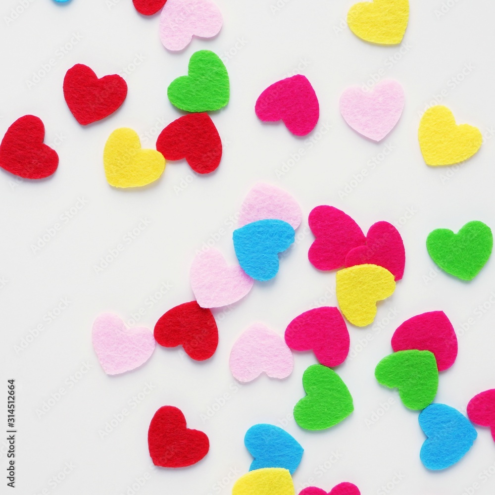 Colored small hearts on a white background. The concept of Valentine's Day, love, color therapy. Square, top view, flat lay. Colored small hearts on a white background. The concept of Valentine's Day, love, color therapy. Square, top view, flat lay.