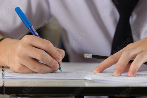 high school,university student study.hands holding pencil writing paper answer sheet.sitting lecture chair taking final exam attending in examination classroom.concept scholarship for education abroad