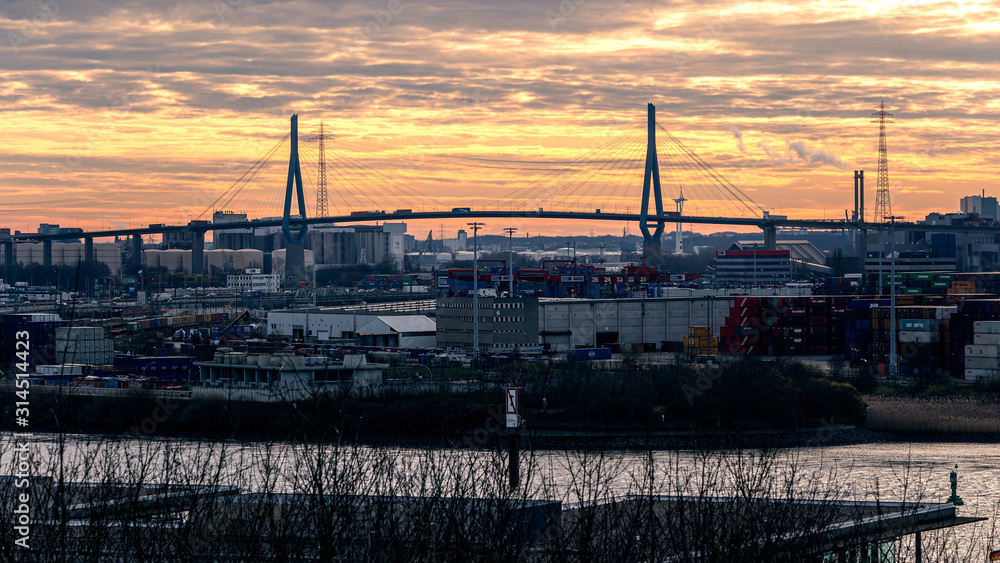 Stunning panoramic view of the Port of Hamburg with the container terminal and the Köhlbrandbrücke bridge at Elbe river at sunset from the roof of Dockland