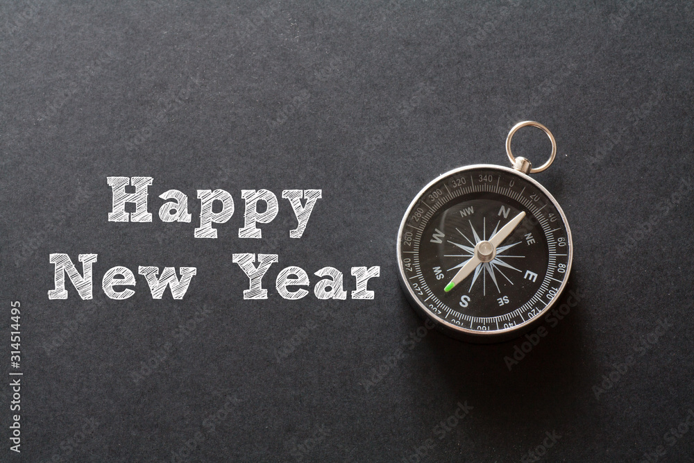 Happy New Year written with Compass on black paper background Happy New Year written with Compass on black paper background