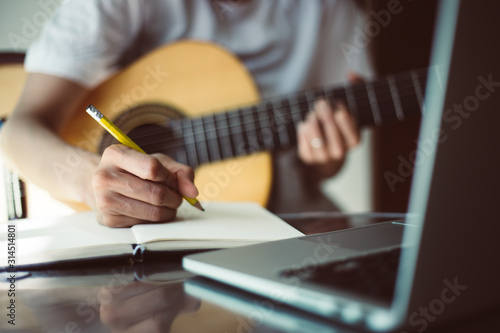 artist songwriter thinking writing notes,lyrics in book at studio.man playing live acoustic guitar relax chill.concept for musician creative.composer work process.people relaxing time with instrument photo