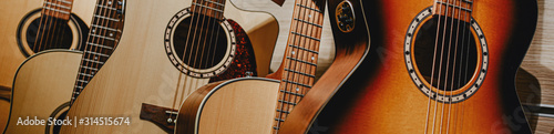 banner guitars are displayed in a row in a music store