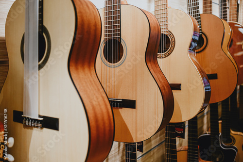 banner guitars are displayed in a row in a music store