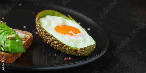 fried eggs in avocado (healthy breakfast, vitamins) menu concept. food background. top view. copy space