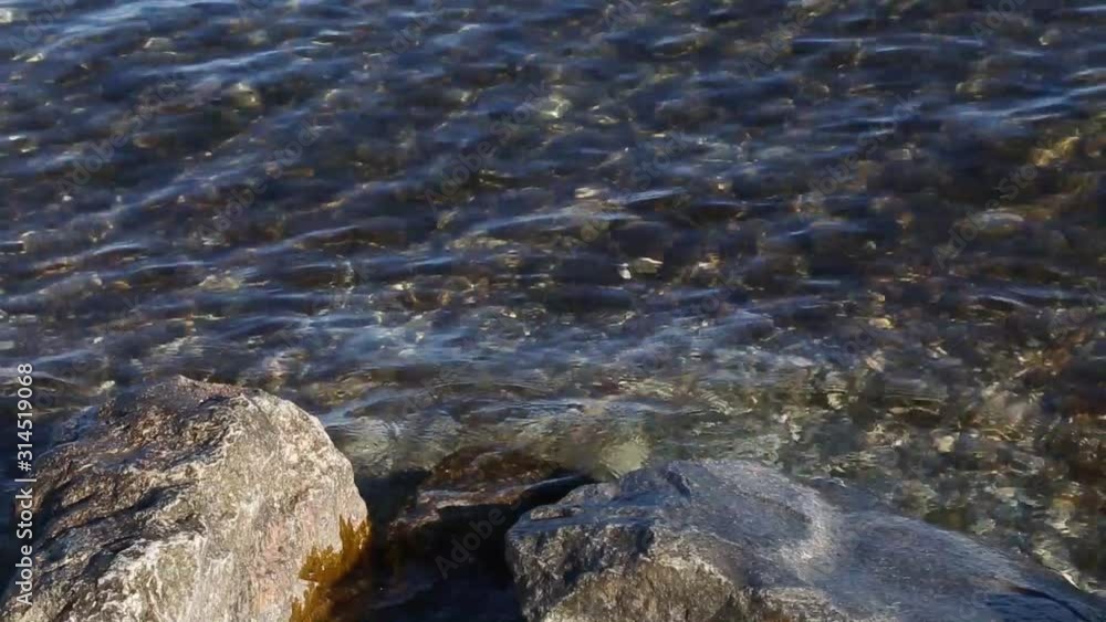 Movement of the transparent and clean water of Lake Garda. Close-up. Staycations concept of tourism in Italy. Movement of the transparent and clean water of Lake Garda. Close-up. Staycations concept of tourism in Italy.
