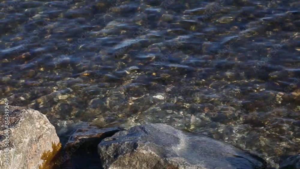 Movement of the transparent and clean water of Lake Garda. Close-up. Staycations concept of tourism in Italy.