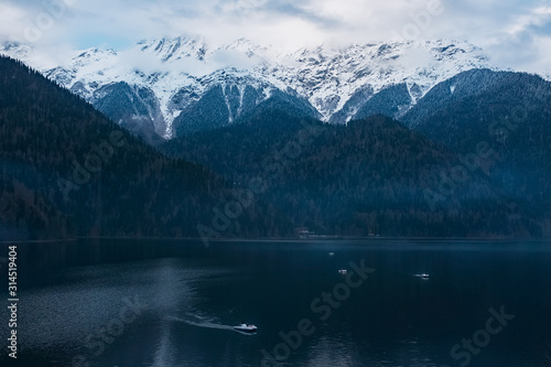 Winter lake Ritsa in Abkhazia with mountains in the snow in the background, late evening. © Alexander