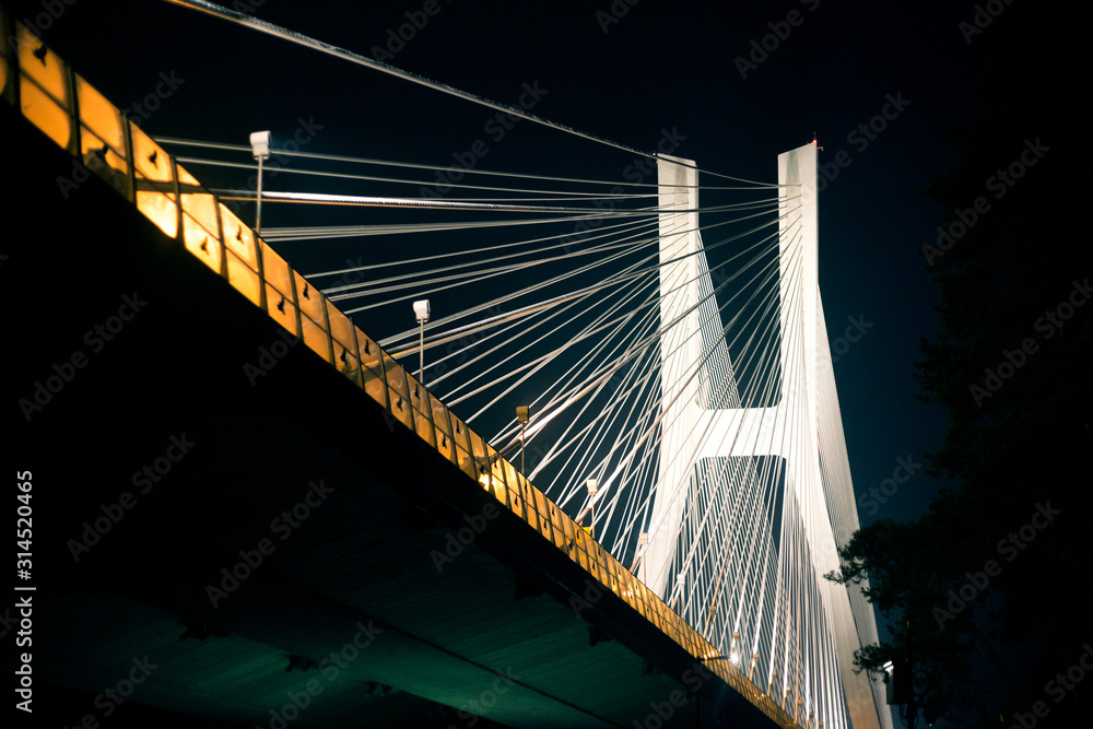 Obraz premium Suspension bridge at night on illuminated iron cables in Wroclaw