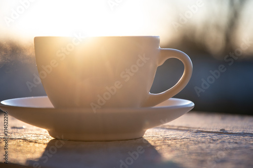 Morning cup of coffee outdoors at dawn.