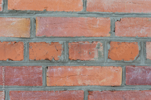 Weathered stained old red brick wall background. Close up