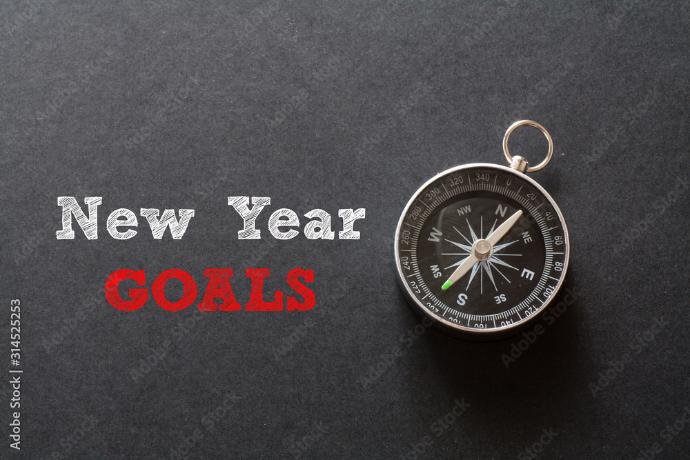 New Year Goals written with Compass on black paper background New Year Goals written with Compass on black paper background