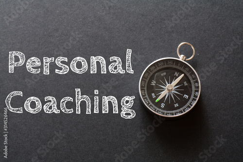 Written Personal Coaching words on black background with compass