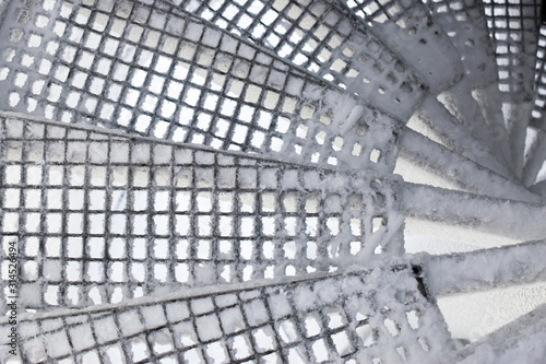 The spiral staircase is covered in snow. Dangerous descent