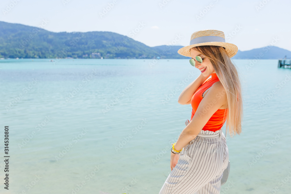 girl in stylish clothes with sunglasses and boater posing near t girl in stylish clothes with sunglasses and boater posing near t
