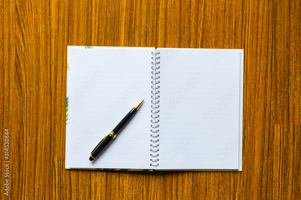 close up opening note paper and pen on wood texture background with copy space close up opening note paper and pen on wood texture background with copy space