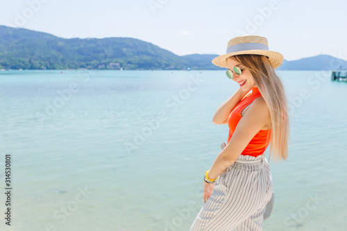 girl in stylish clothes with sunglasses and boater posing near t