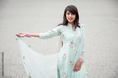 Portrait of an Indian young girl. Girl in traditional Indian clothing, salwar kameez. Girl traditional Indian decorations, bindi, chudiyan, jumka photo