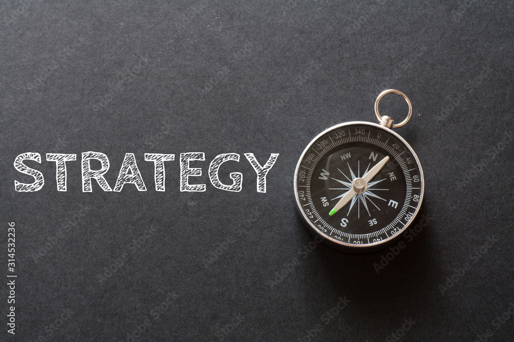Written STRATEGY words on black background with compass Written STRATEGY words on black background with compass