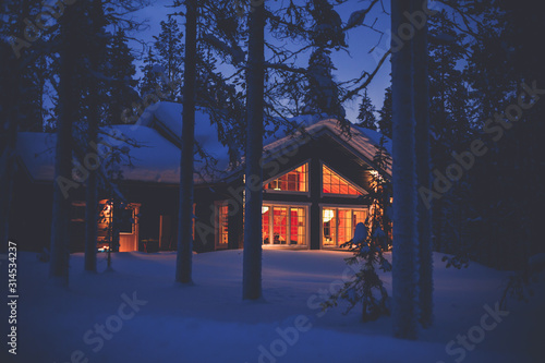 Canvas-taulu A cozy wooden cabin cottage chalet house covered in snow near ski resort in wint