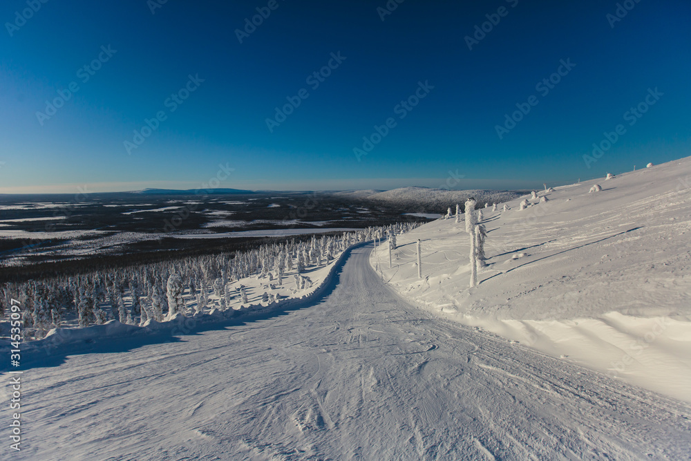 Beautiful vibrant aerial winter mountain view of ski resort, sunny winter day with slope, piste and ski lift Beautiful vibrant aerial winter mountain view of ski resort, sunny winter day with slope, piste and ski lift