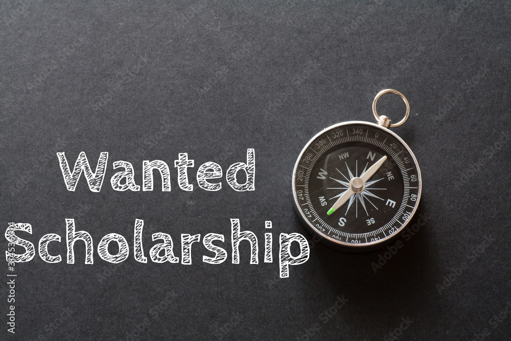 Written Wanted Scholarship words on black background with compass Written Wanted Scholarship words on black background with compass