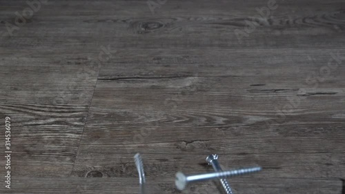 Screws falling onti a wooden table photo