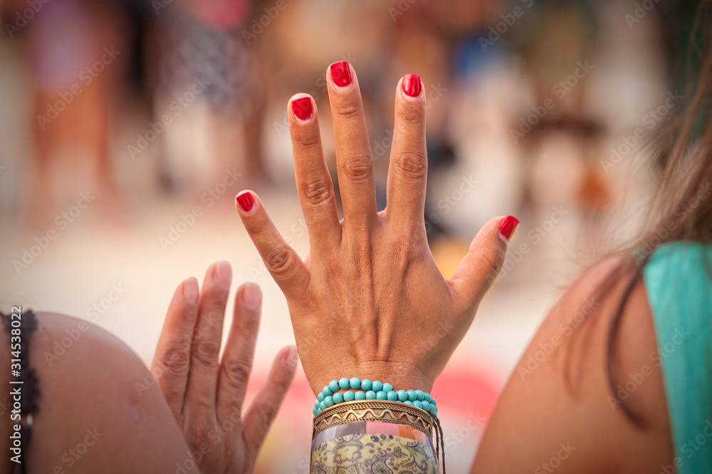 Naklejka premium Female hand with bracelets. Close up of female hands. The hands of a woman shaman during cleansing ritual in Playa del Carmen Mexico.