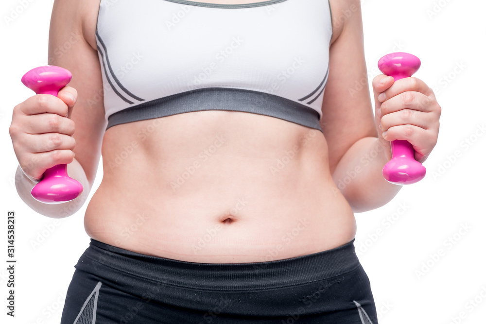 weight loss, belly close up and in the hands of a dumbbell weight loss, belly close up and in the hands of a dumbbell