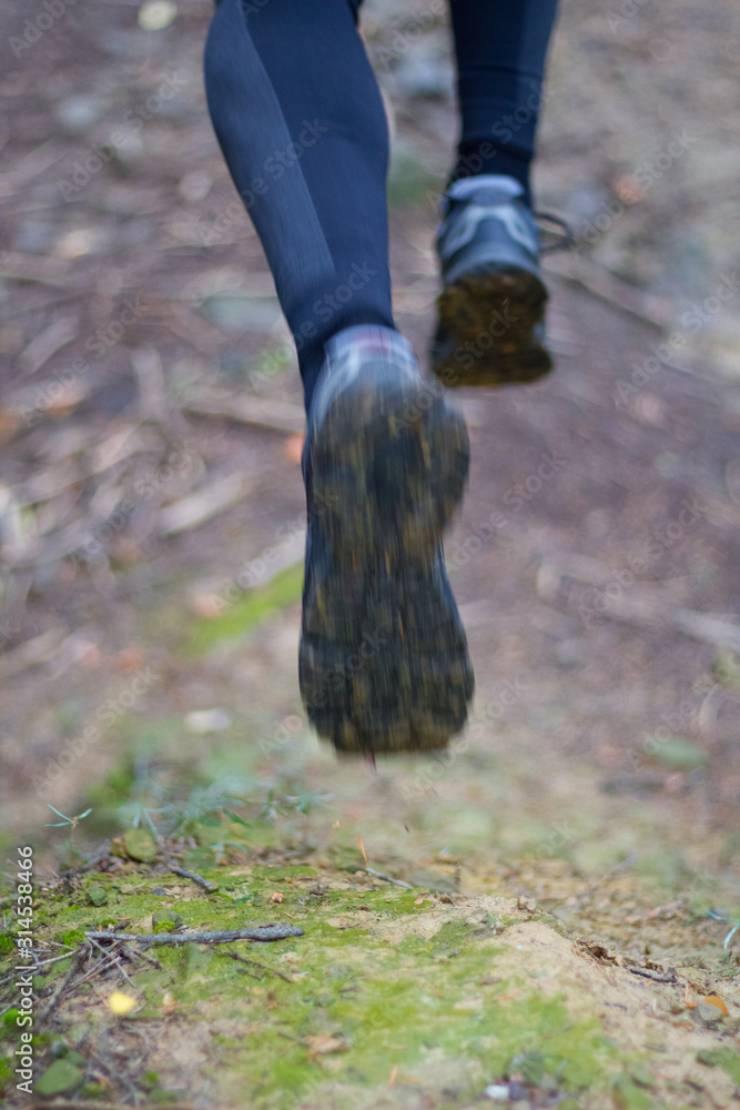 Male feet running on trail in mountains