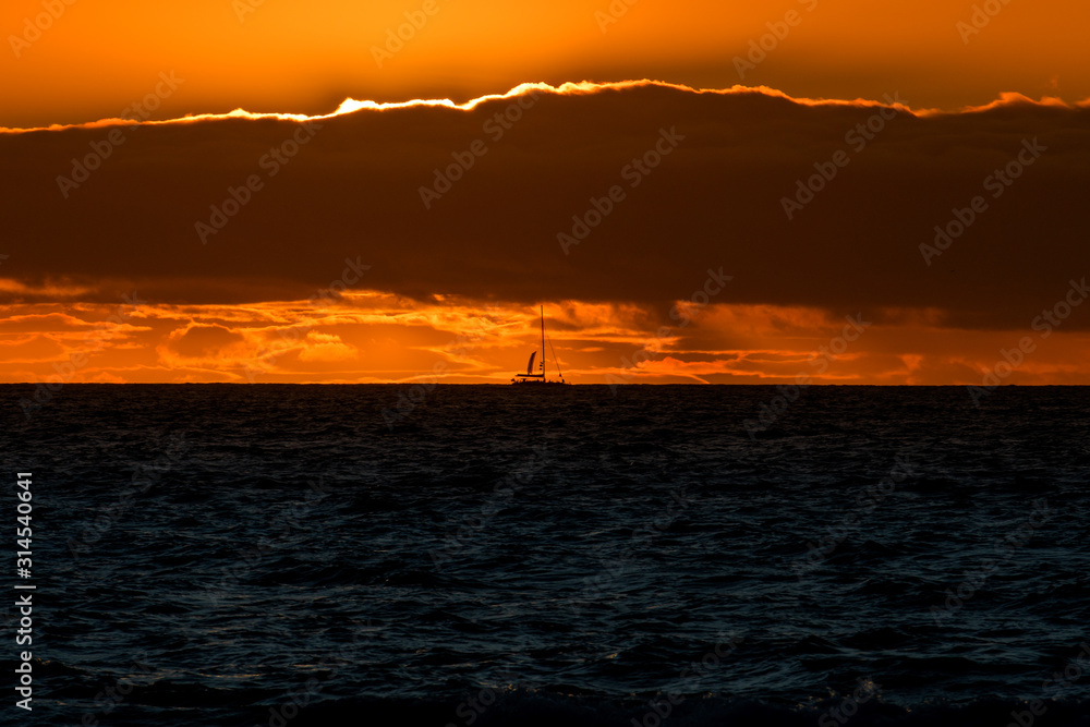Natural marine landscape with amazing sunset over the ocean in Tenerife Canary Island Spain. Summer exotic vacation postcard from tropical island. Wonderful orange sunrise over the water behind clouds Natural marine landscape with amazing sunset over the ocean in Tenerife Canary Island Spain. Summer exotic vacation postcard from tropical island. Wonderful orange sunrise over the water behind clouds