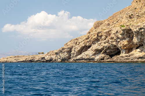 View from a motor boat on the mediterranean sea at the rocky coastline near Stegna on the eastside of Greek island Rhodes