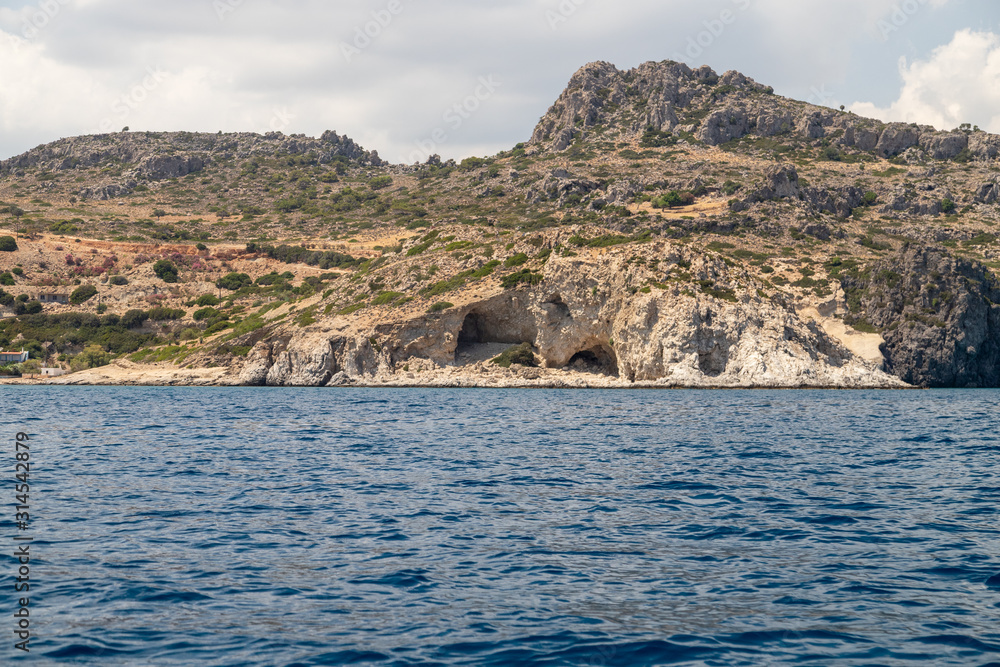 View from a motor boat on the mediterranean sea at the rocky coastline near Stegna on the eastside of Greek island Rhodes View from a motor boat on the mediterranean sea at the rocky coastline near Stegna on the eastside of Greek island Rhodes