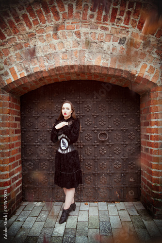 Młoda kobieta na tle gotyckiej bramy