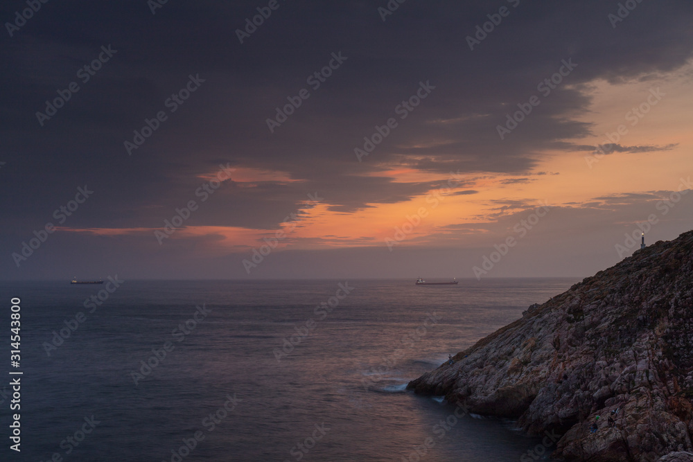Ships crossing the sea at sunset in the surroundings of Avilés, Asturias, Spain.
