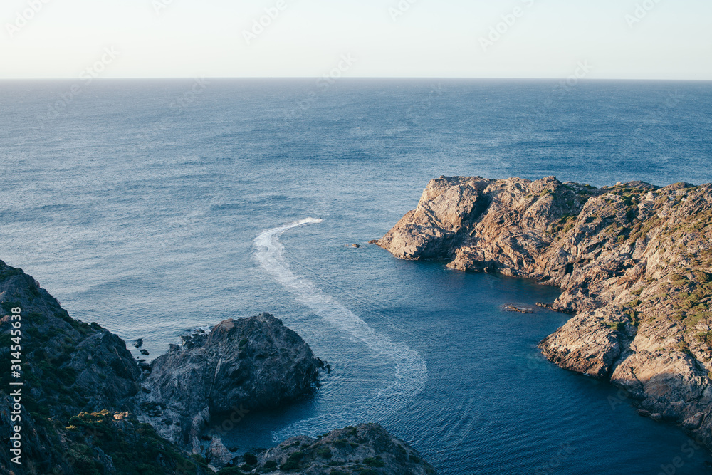 gulf in the mediterranean sea with cliffs and rocks with a person riding a jet ski