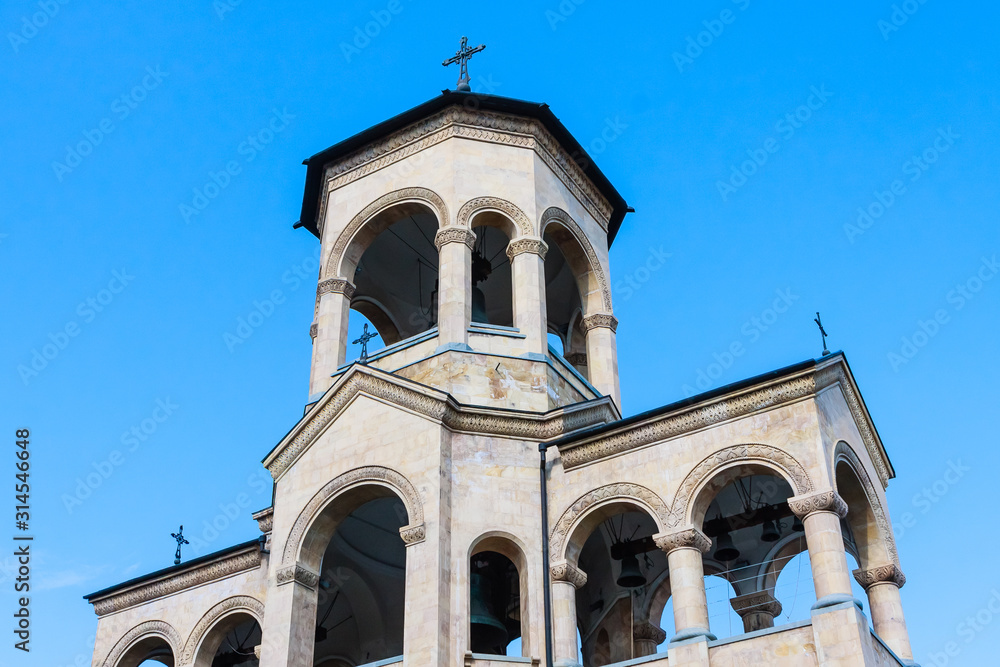 Fototapeta premium View to chapel on site to Sameba Cathedral Tsminda in Tbilisi (Holy Trinity). Biggest church Orthodox in Caucasus Georgia region in a sunny day. The main cathedral of the Georgian Orthodoxy