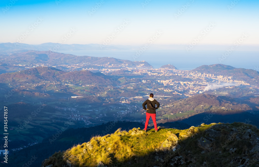 Mountaineer on top of Aiako Harriak with the city of Donostia in the background, Euskadi