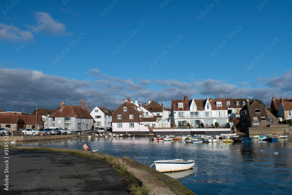 Emsworth harbour a beautiful view of small boats Swans and buildings reflecting in the water.