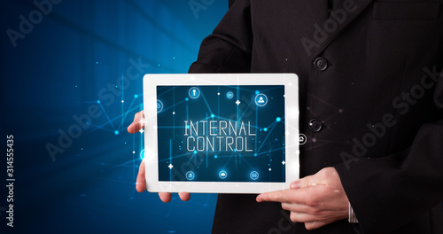 Wallpaper Mural Young business person working on tablet and shows the digital sign: INTERNAL CONTROL Torontodigital.ca
