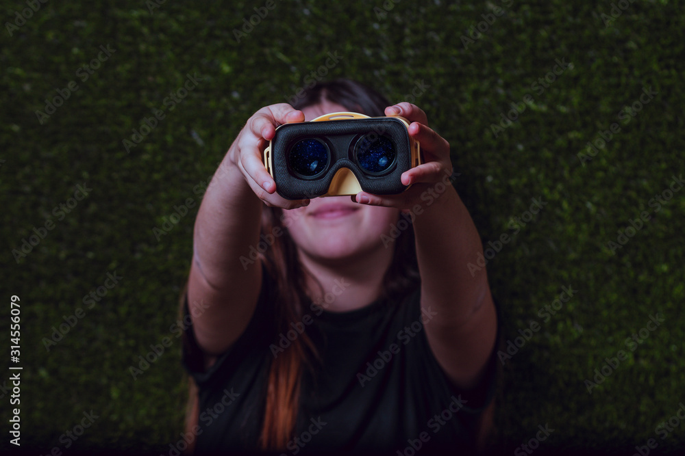 Girl with a black t-shirt showing yellow virtual reality glasses on the inside Girl with a black t-shirt showing yellow virtual reality glasses on the inside