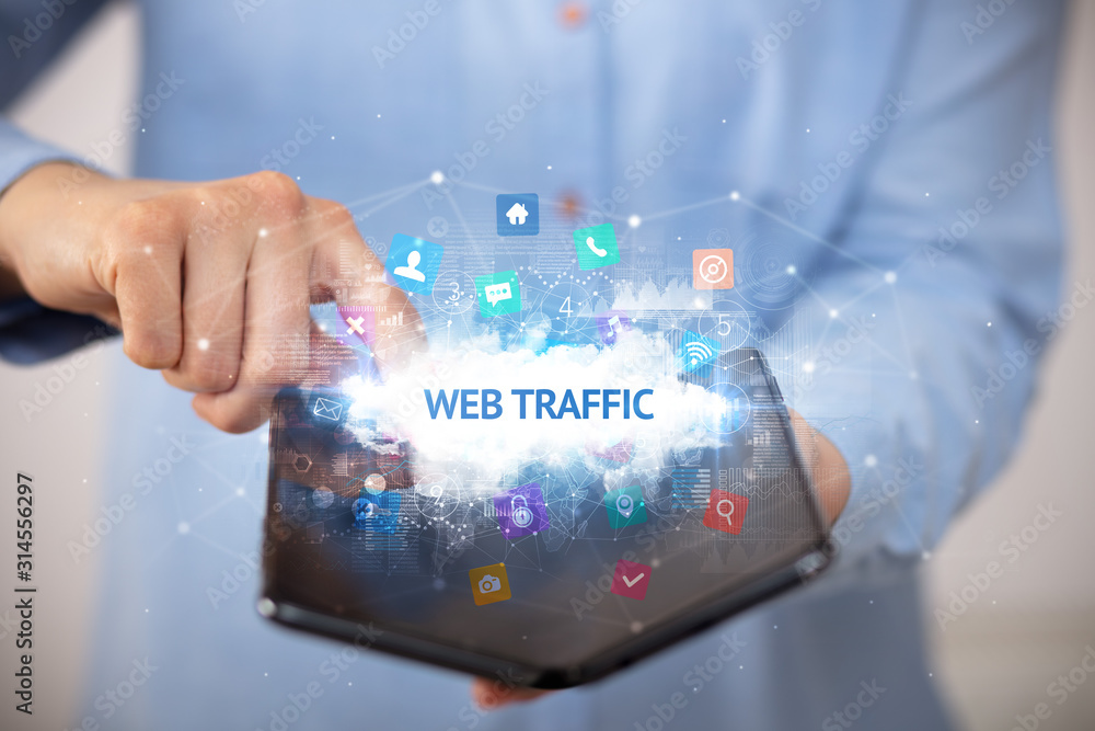 Businessman holding a foldable smartphone with WEB TRAFFIC inscription, technology concept Businessman holding a foldable smartphone with WEB TRAFFIC inscription, technology concept