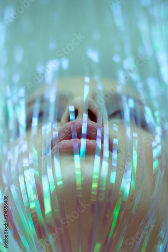 Fotografie Artistic photo of a girl with a tinsel on her face