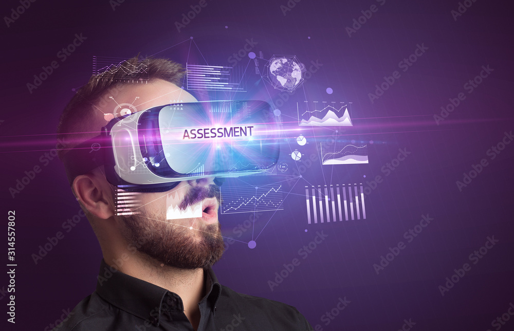 Businessman looking through Virtual Reality glasses with ASSESSMENT inscription, new business concept Businessman looking through Virtual Reality glasses with ASSESSMENT inscription, new business concept