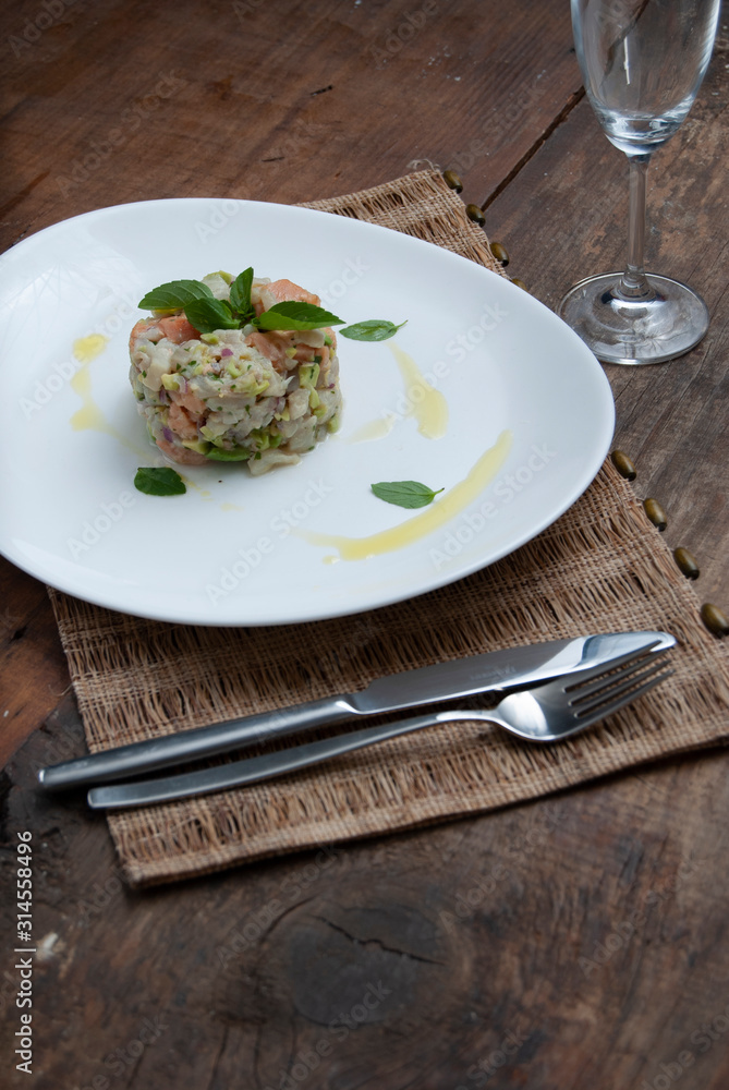 Tartar salmon with herbs on white dish Tartar salmon with herbs on white dish