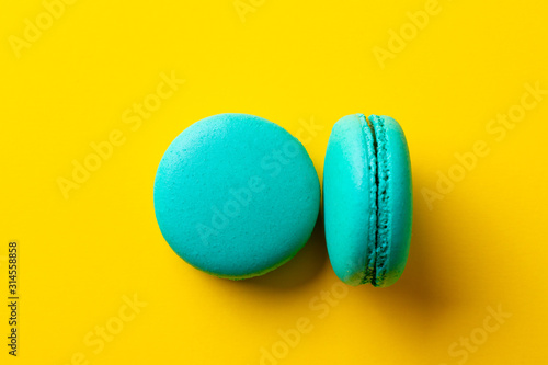 Macaroons dessert on yellow background. Close up. Top view.