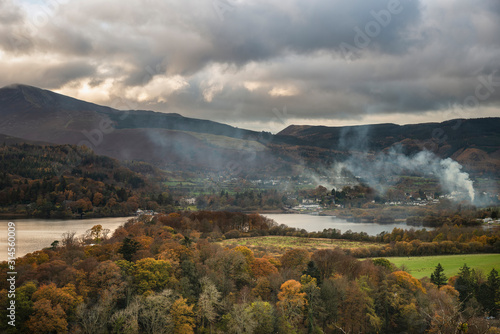 Majestic Autumn Fall landscape image of view from Castlehead in Lake District over Derwentwater towards Catbells and Grisedale Pike at sunset with epic lighting in sky