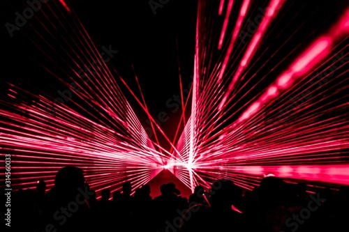 Canvas Print Red laser show nightlife club stage with party people crowd