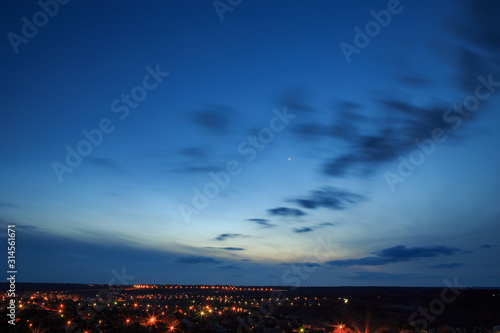 Panorama of a night small town with a blue sky