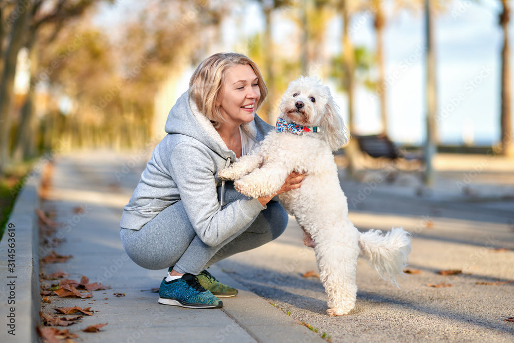 Elderly woman walking with a dog outdoors. Elderly woman walking with a dog outdoors.