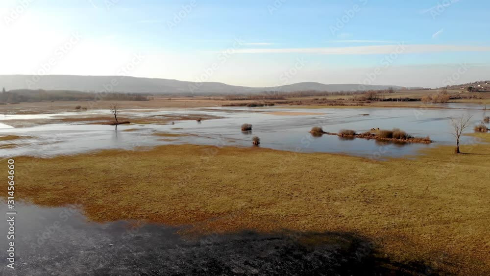 Aerial winter landscape over frozen pond in sunset light Aerial winter landscape over frozen pond in sunset light